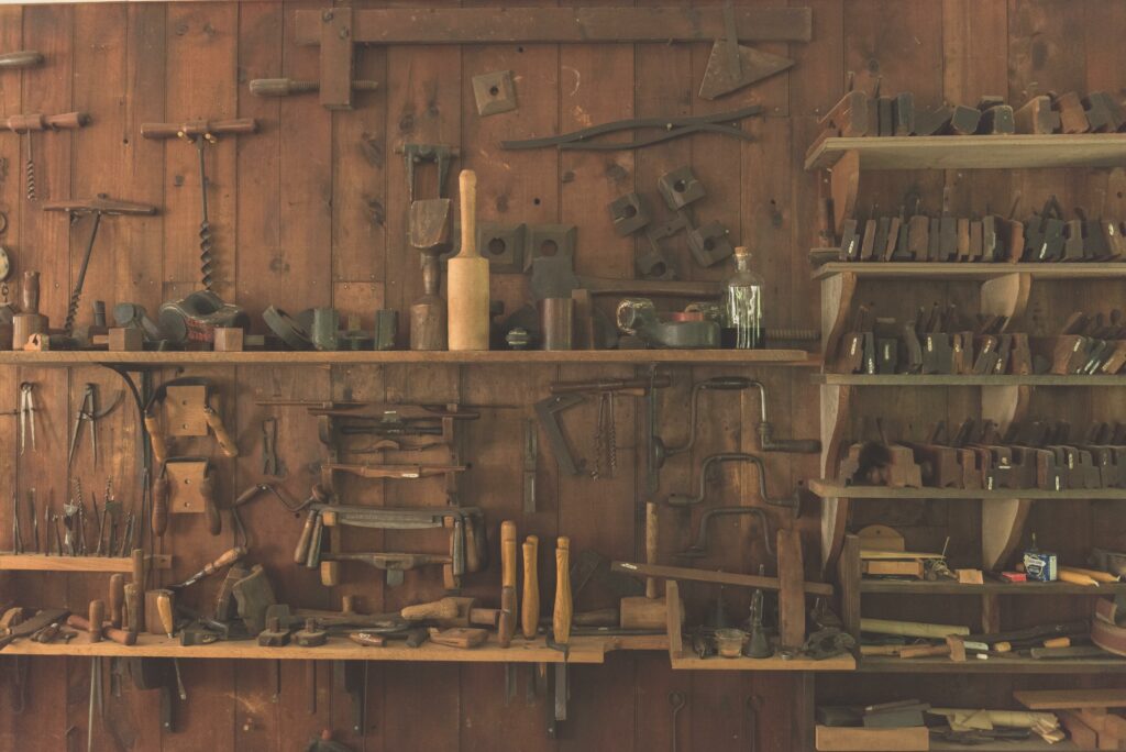 Werkzeug in Regalen vor Holzwand